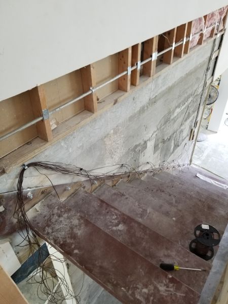Installing lighting under floating staircase. 