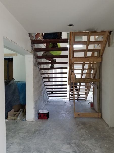 Installing lighting under floating staircase. 