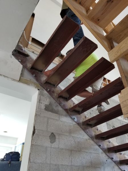 Installing lighting under floating staircase. 