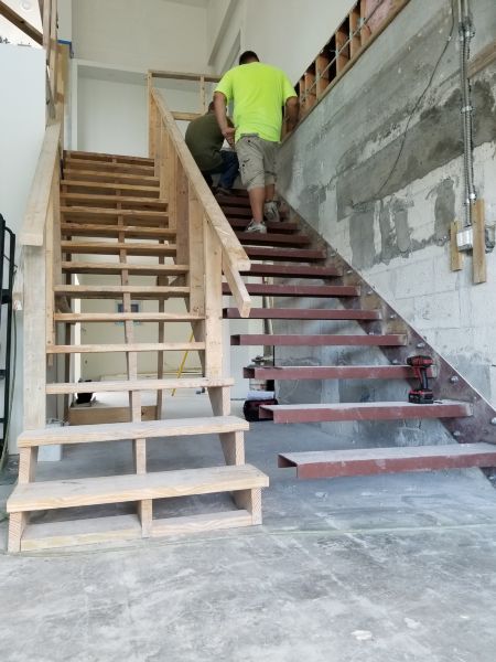 Installing lighting under floating staircase. 
