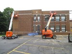 Grind out and tuck point school walls at school with boom lifts