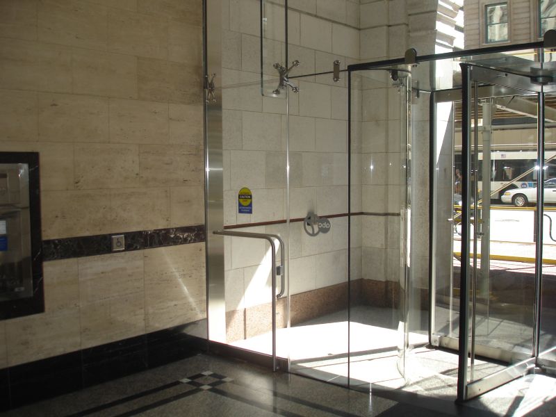 In ground automatic swing door operator for all glass entryway