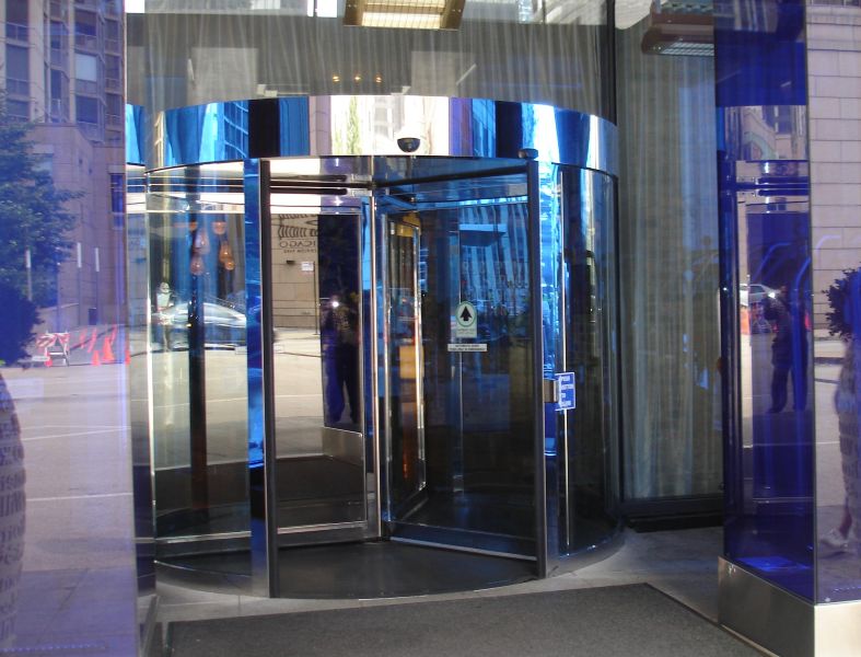 Stainless steel clad automatic revolving door assembly